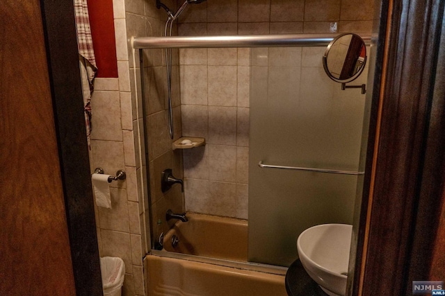 bathroom with shower / bath combination with glass door and toilet