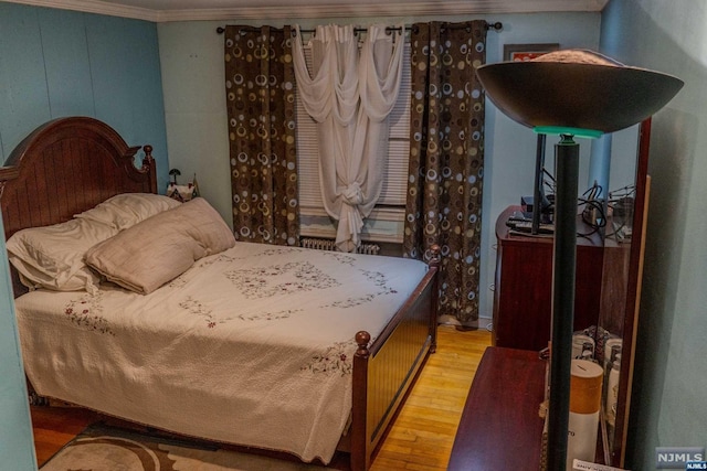 bedroom featuring crown molding and hardwood / wood-style flooring