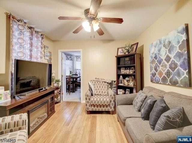 living room with light hardwood / wood-style flooring and ceiling fan