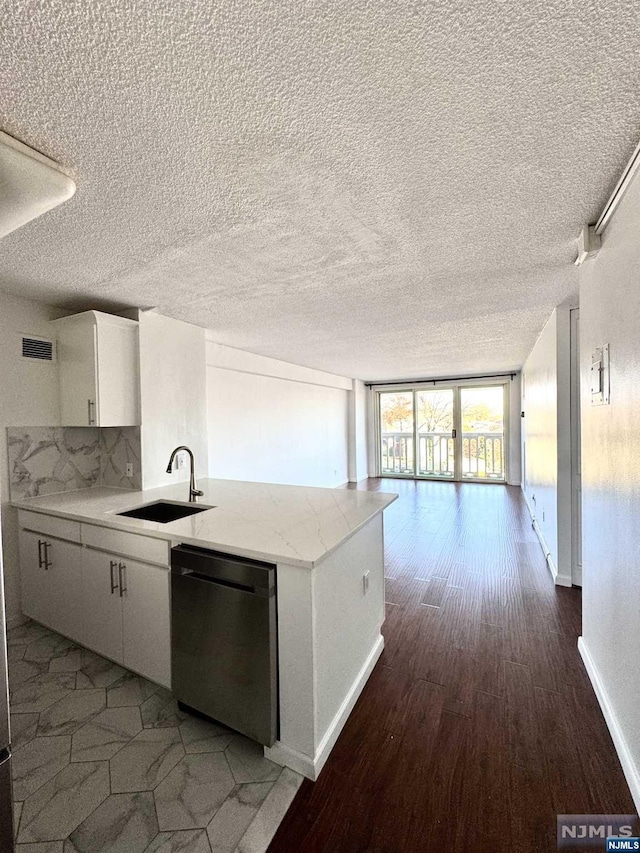 kitchen with stainless steel dishwasher, a textured ceiling, sink, dark hardwood / wood-style floors, and white cabinetry