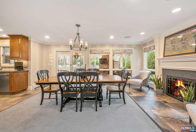 dining room with a chandelier, plenty of natural light, and ornamental molding