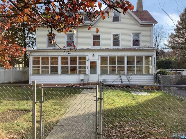 view of front facade with a front lawn and a sunroom