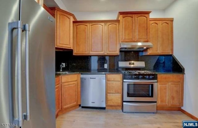 kitchen with decorative backsplash, sink, stainless steel appliances, and light hardwood / wood-style floors