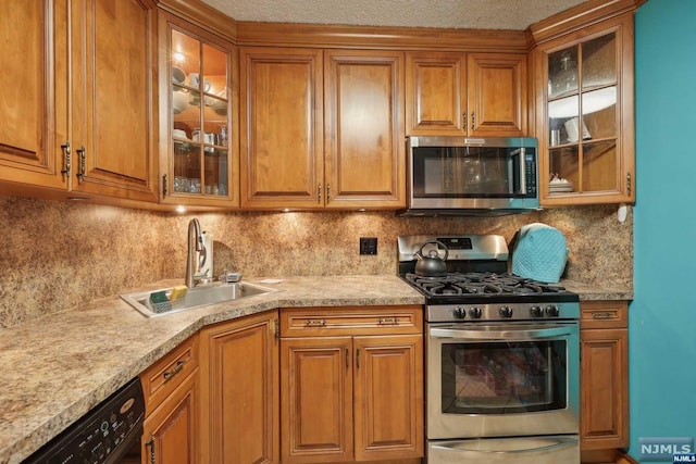 kitchen with tasteful backsplash, sink, stainless steel appliances, and a textured ceiling