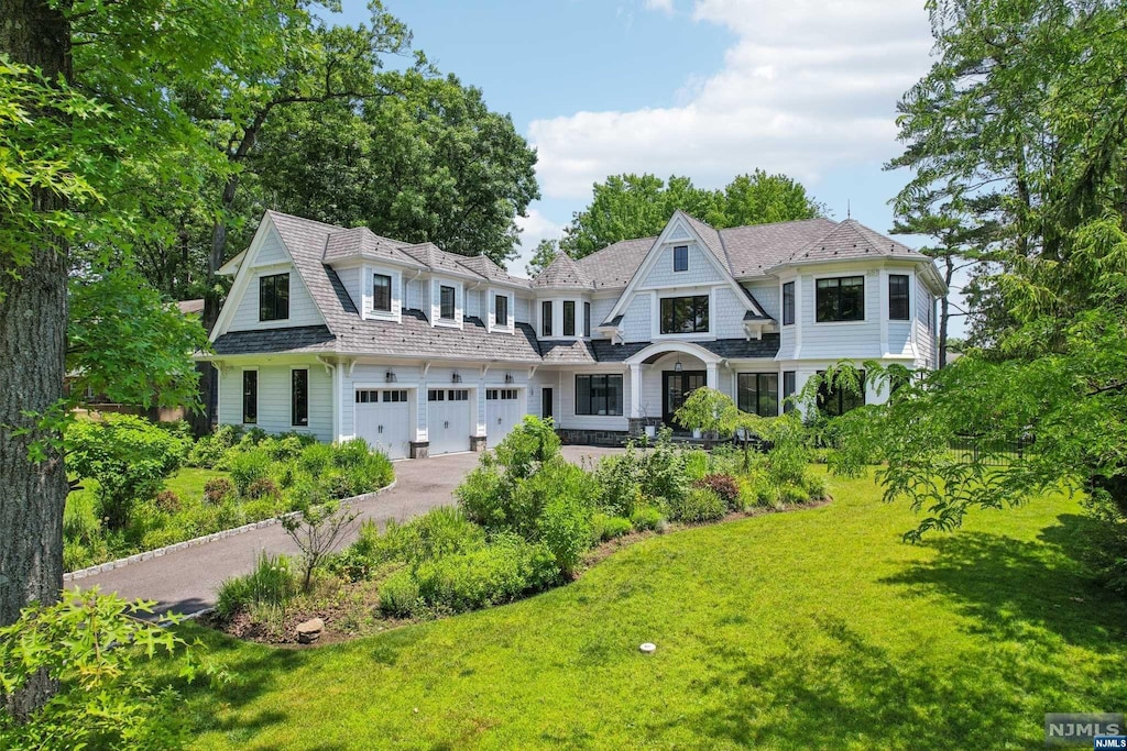 view of front of house featuring a front lawn and a garage