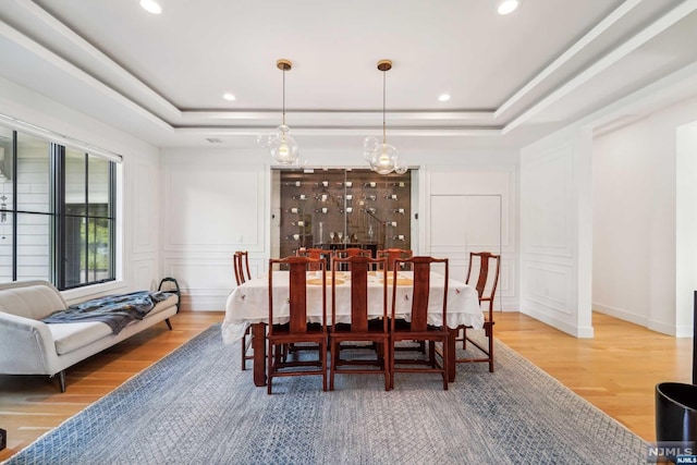 dining area featuring hardwood / wood-style flooring and a raised ceiling