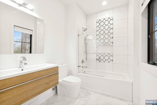 full bathroom with vanity, toilet, and tiled shower / bath