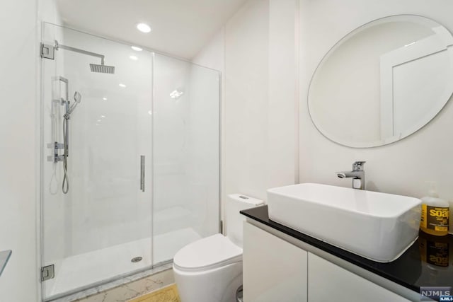 bathroom featuring vanity, toilet, and a shower with shower door