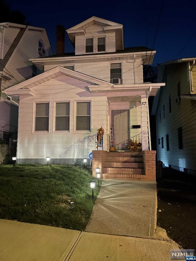 italianate home featuring a yard and cooling unit