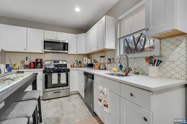 kitchen with appliances with stainless steel finishes, backsplash, and white cabinetry