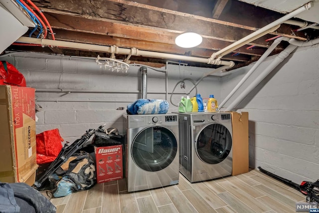 washroom featuring hardwood / wood-style floors and washing machine and clothes dryer