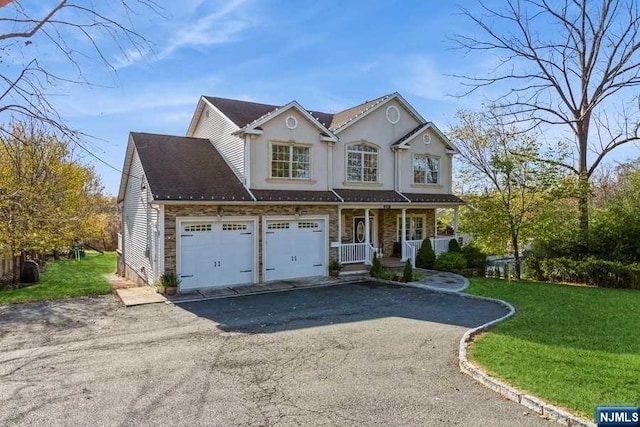 view of front property featuring a front yard, a porch, and a garage