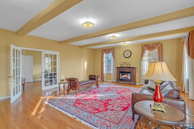 living room featuring beam ceiling, french doors, and light hardwood / wood-style flooring