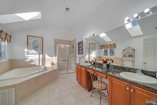 bathroom with tile patterned flooring, vanity, lofted ceiling with skylight, and independent shower and bath