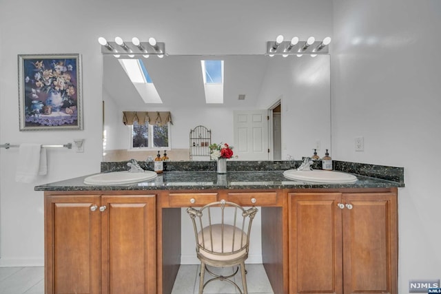 bathroom featuring tile patterned flooring, vanity, and vaulted ceiling with skylight