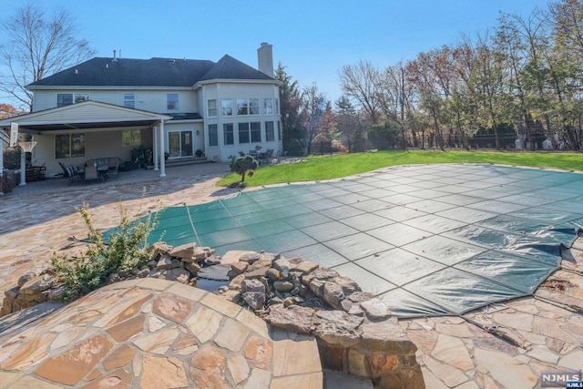 view of pool featuring a yard and a patio