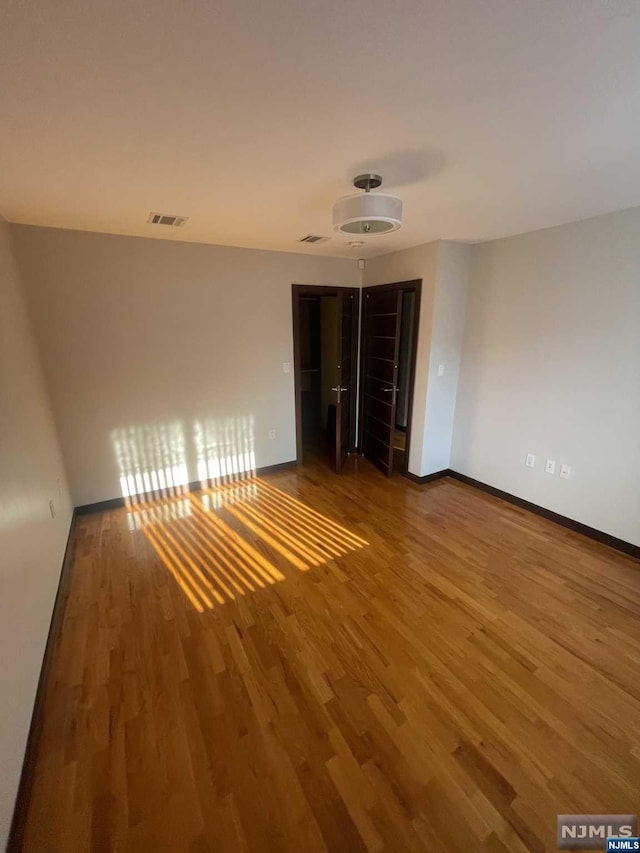 spare room with wood-type flooring