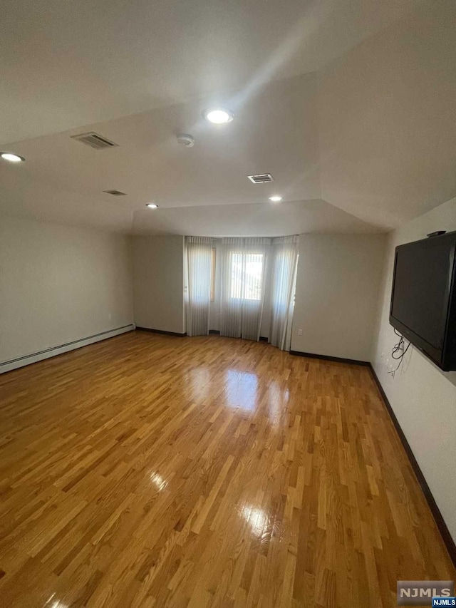 unfurnished room featuring light hardwood / wood-style floors and vaulted ceiling