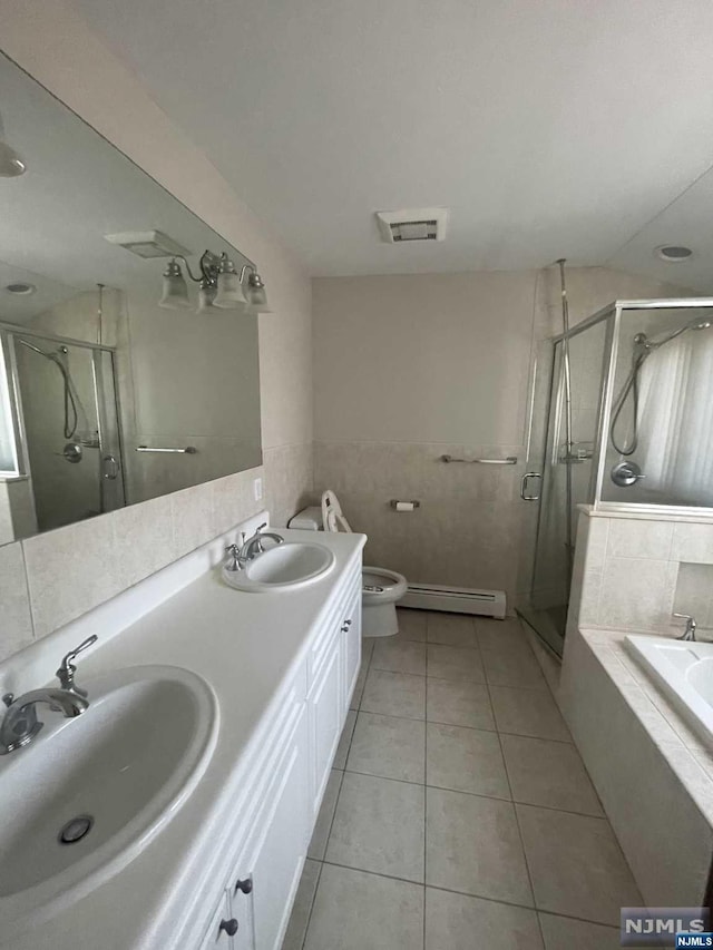 full bathroom with plus walk in shower, a baseboard heating unit, tile patterned floors, toilet, and vanity