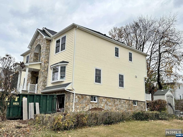 view of side of home featuring a storage unit