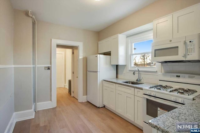 kitchen with white cabinetry, white appliances, sink, and tasteful backsplash