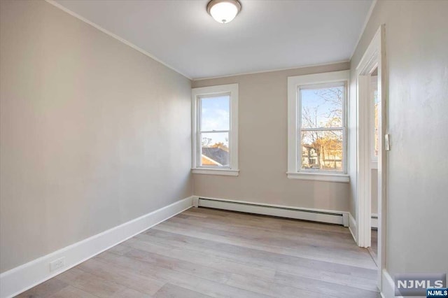 empty room featuring light wood-type flooring and a baseboard radiator