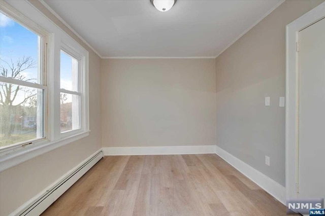 unfurnished room featuring crown molding, light hardwood / wood-style flooring, and a baseboard heating unit