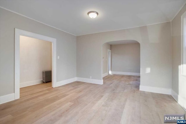 empty room featuring light hardwood / wood-style floors and radiator heating unit