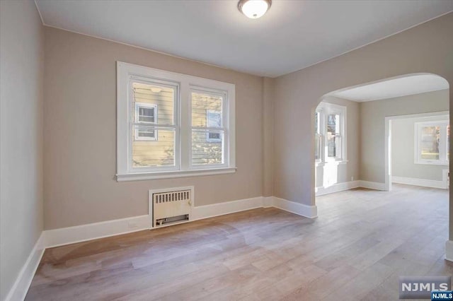 empty room with radiator and light hardwood / wood-style floors