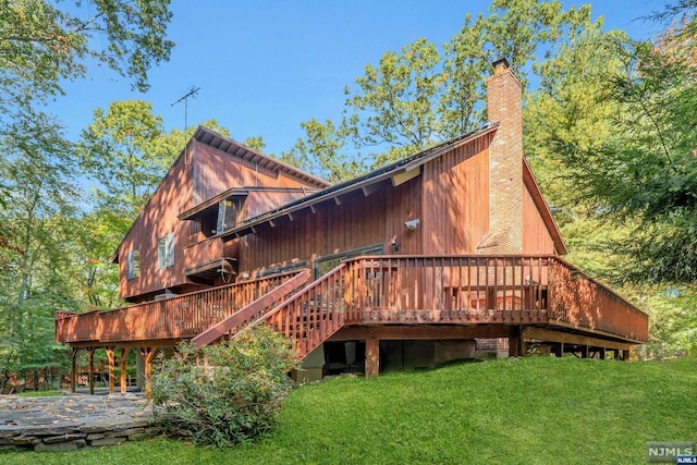 rear view of house featuring a lawn, a patio area, and a wooden deck