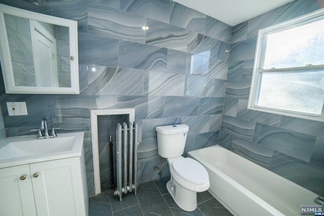 bathroom featuring tile patterned flooring, vanity, toilet, and tile walls