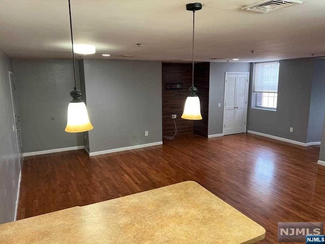 unfurnished living room featuring dark hardwood / wood-style floors and wooden walls