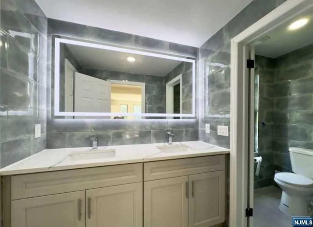 bathroom featuring vanity, tile walls, decorative backsplash, and toilet