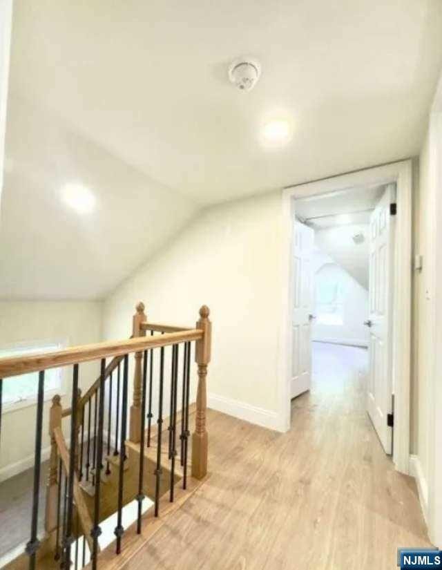 bonus room featuring lofted ceiling and light wood-type flooring