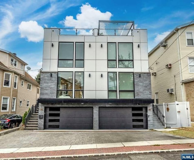 contemporary home featuring a wall mounted air conditioner and a garage