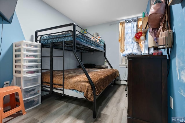 bedroom featuring hardwood / wood-style floors and baseboard heating