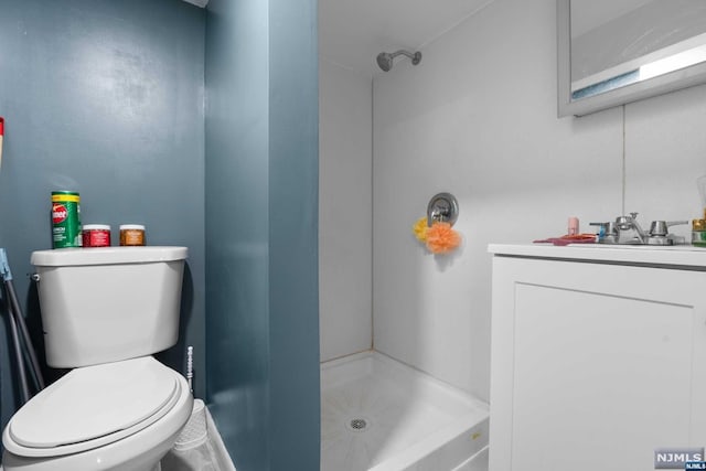 bathroom featuring a shower, vanity, and toilet