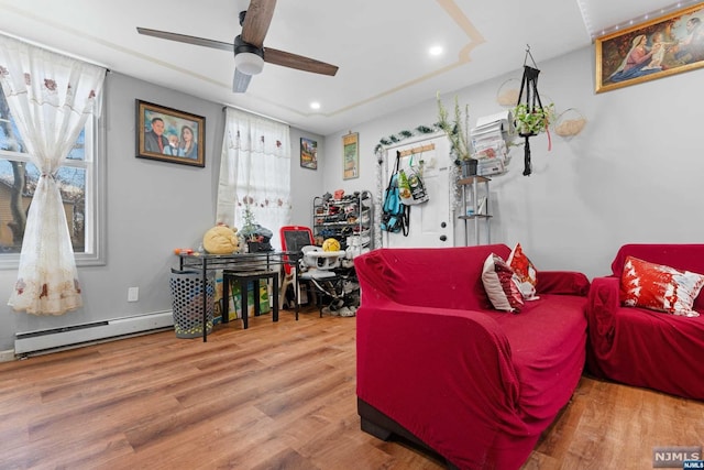 living room with hardwood / wood-style flooring, plenty of natural light, ceiling fan, and a baseboard radiator