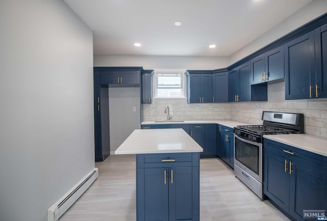 kitchen featuring light wood-type flooring, stainless steel gas range, baseboard heating, sink, and a center island