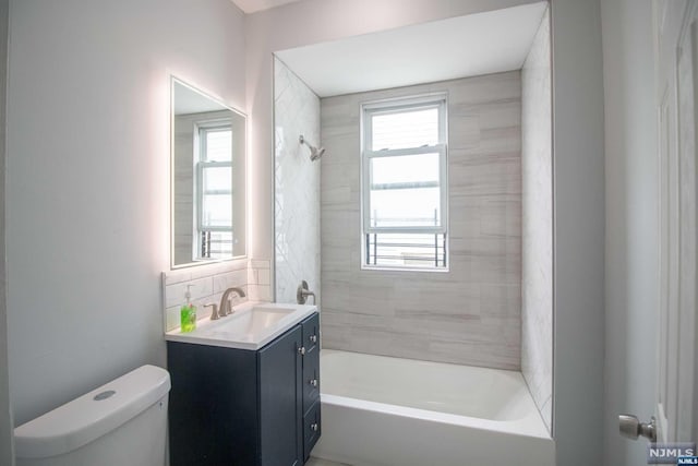 full bathroom with vanity, tiled shower / bath, and toilet