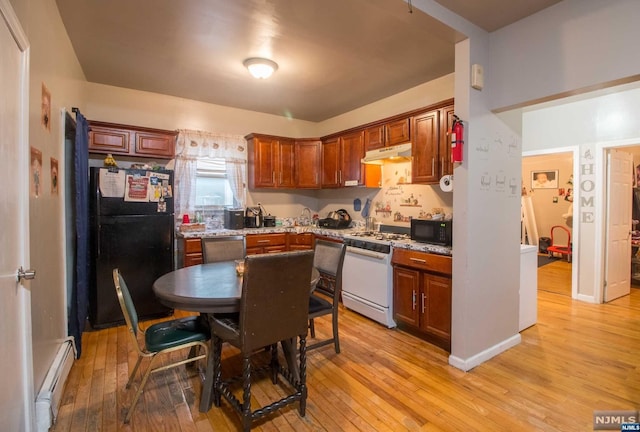 kitchen featuring light stone counters, light hardwood / wood-style flooring, black appliances, and a baseboard heating unit