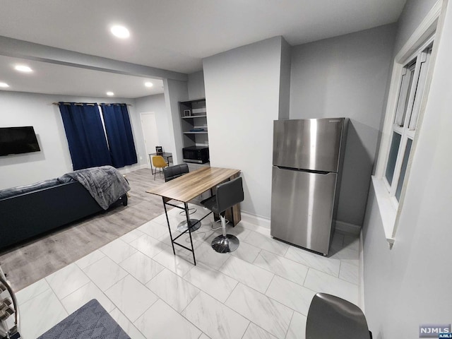 kitchen with stainless steel fridge and light hardwood / wood-style floors