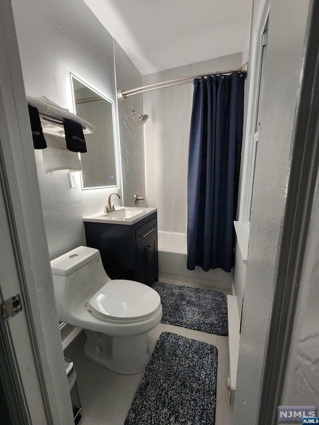 full bathroom featuring tile patterned floors, shower / bath combo with shower curtain, vanity, and toilet