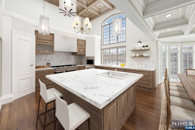 kitchen with sink, coffered ceiling, an inviting chandelier, dark hardwood / wood-style floors, and ornamental molding