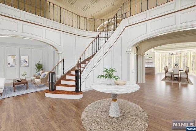 foyer entrance featuring hardwood / wood-style flooring and a towering ceiling