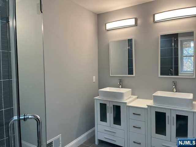 bathroom featuring vanity and an enclosed shower