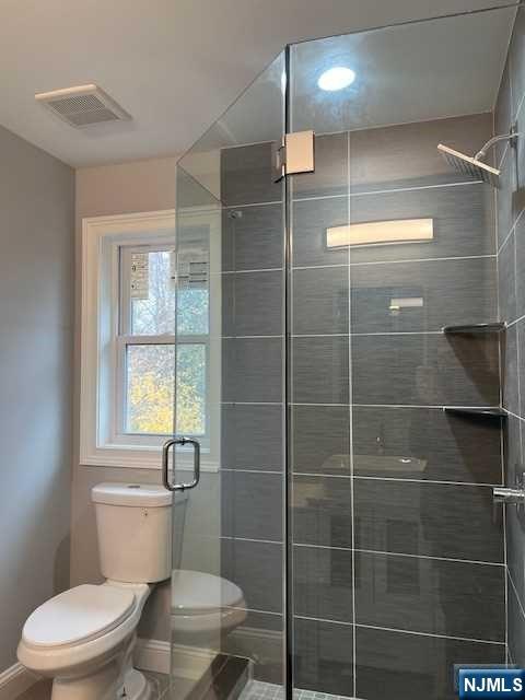 bathroom featuring toilet and walk in shower