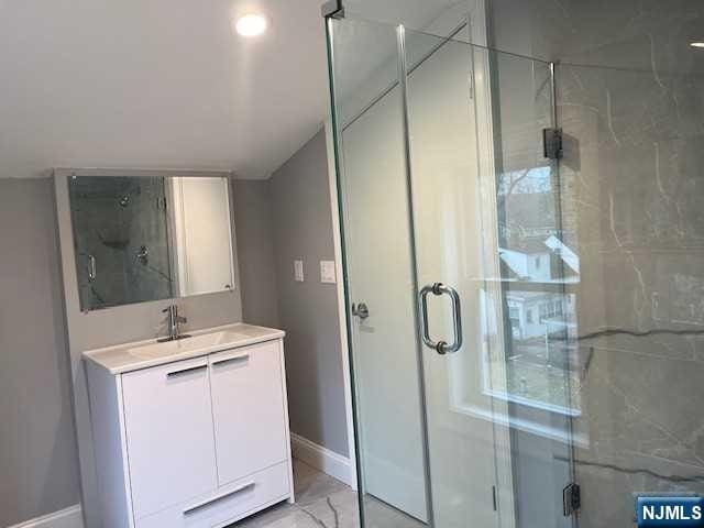 bathroom with vanity and a shower with door