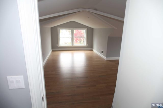 additional living space featuring hardwood / wood-style floors and lofted ceiling