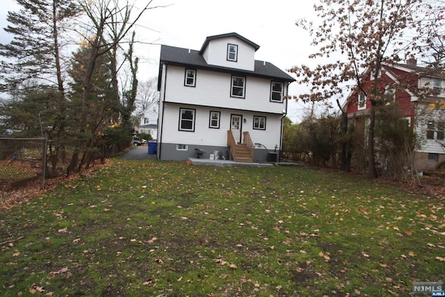 rear view of house featuring a lawn